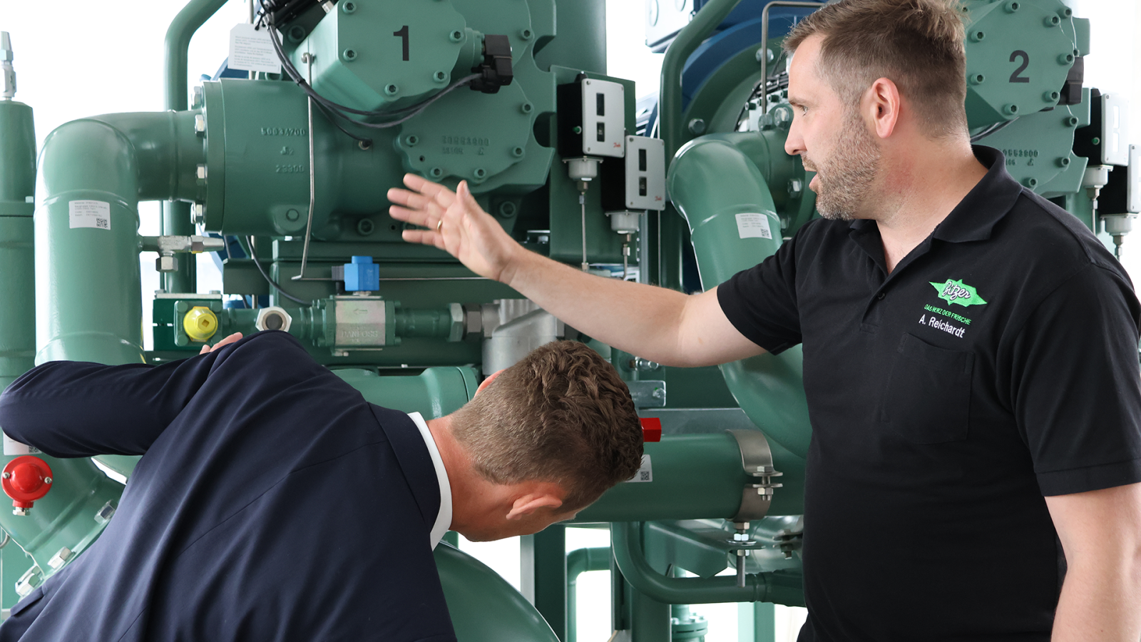 Two person in front of a Amonnia Compressor Pack